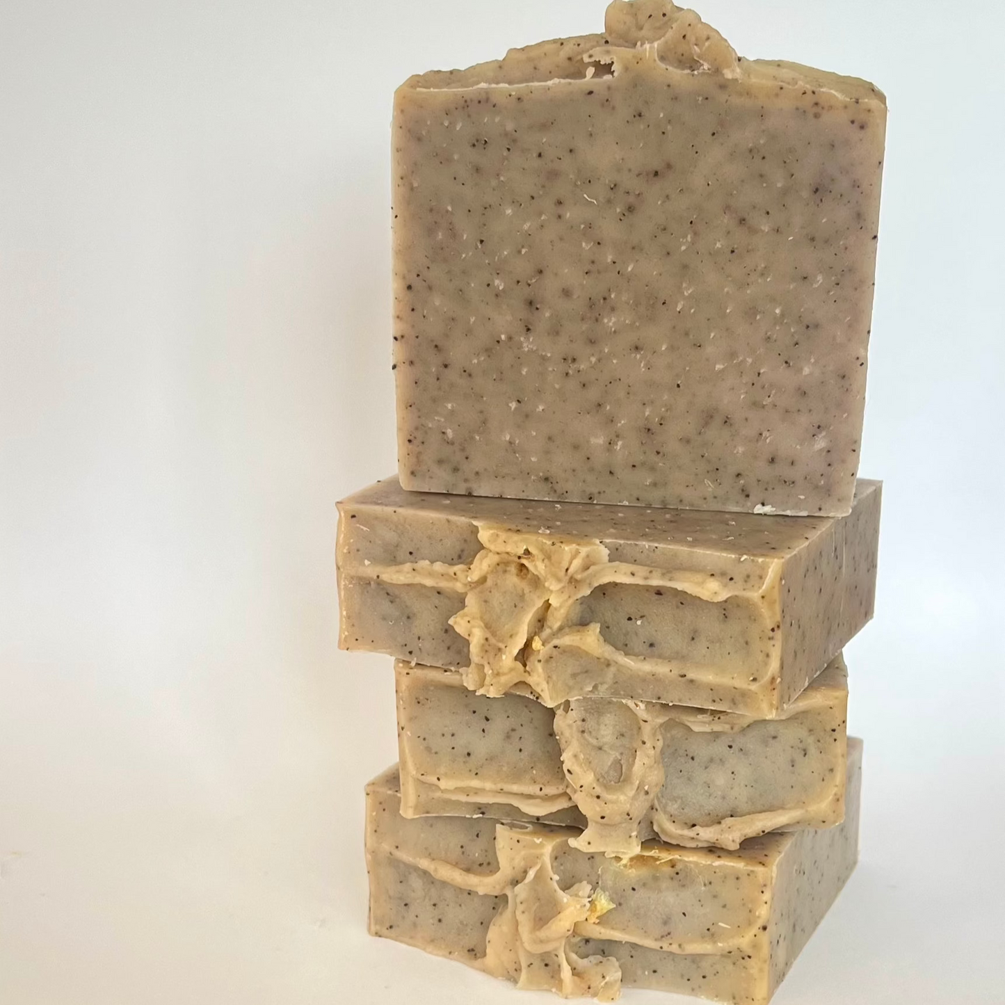 Handgemaakte Garden Glow scrubzeep met gele klei, sheaboter en castorolie, ideaal voor ruwe handen na buitenwerk, met een natuurlijke, opwekkende geur van patchouli en sinaasappel.